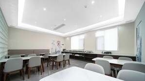 A conference room with white tables and chairs, a large whiteboard, and a projector screen. - Xiyue Ruixuan Hotel (Jingdezhen)