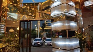 A modern hotel entrance with a glass facade, a staircase, and a parking area with cars. - Xiyue Ruixuan Hotel (Jingdezhen)