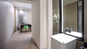 A modern bathroom with a large mirror, a white sink, and a shower area. - Xiyue Ruixuan Hotel (Jingdezhen)