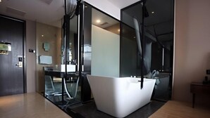 A modern bathroom with a freestanding bathtub, a glass shower enclosure, and a visible toilet. - Xiyue Ruixuan Hotel (Jingdezhen)