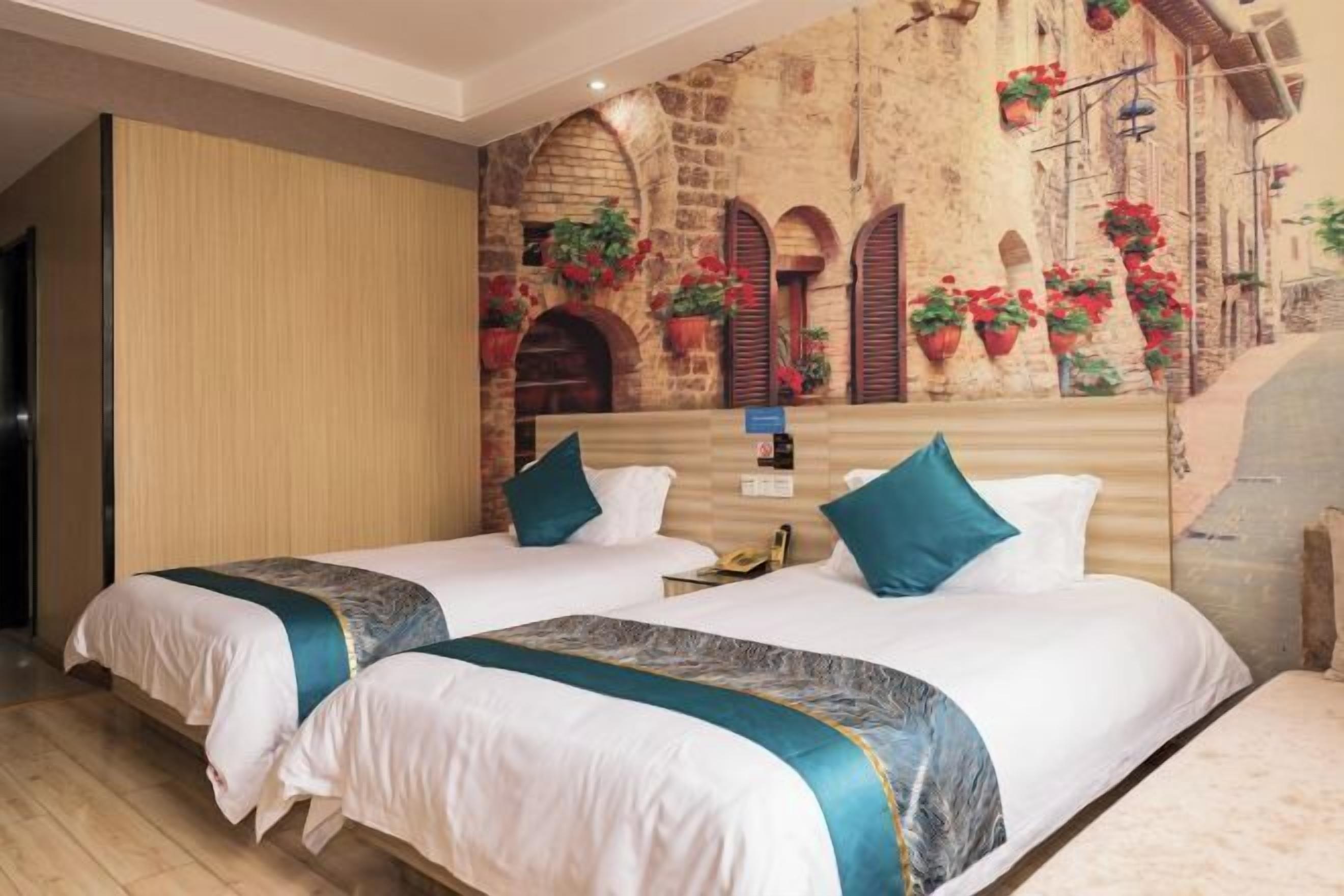 A hotel room with two beds, a stone wall mural, and potted plants.