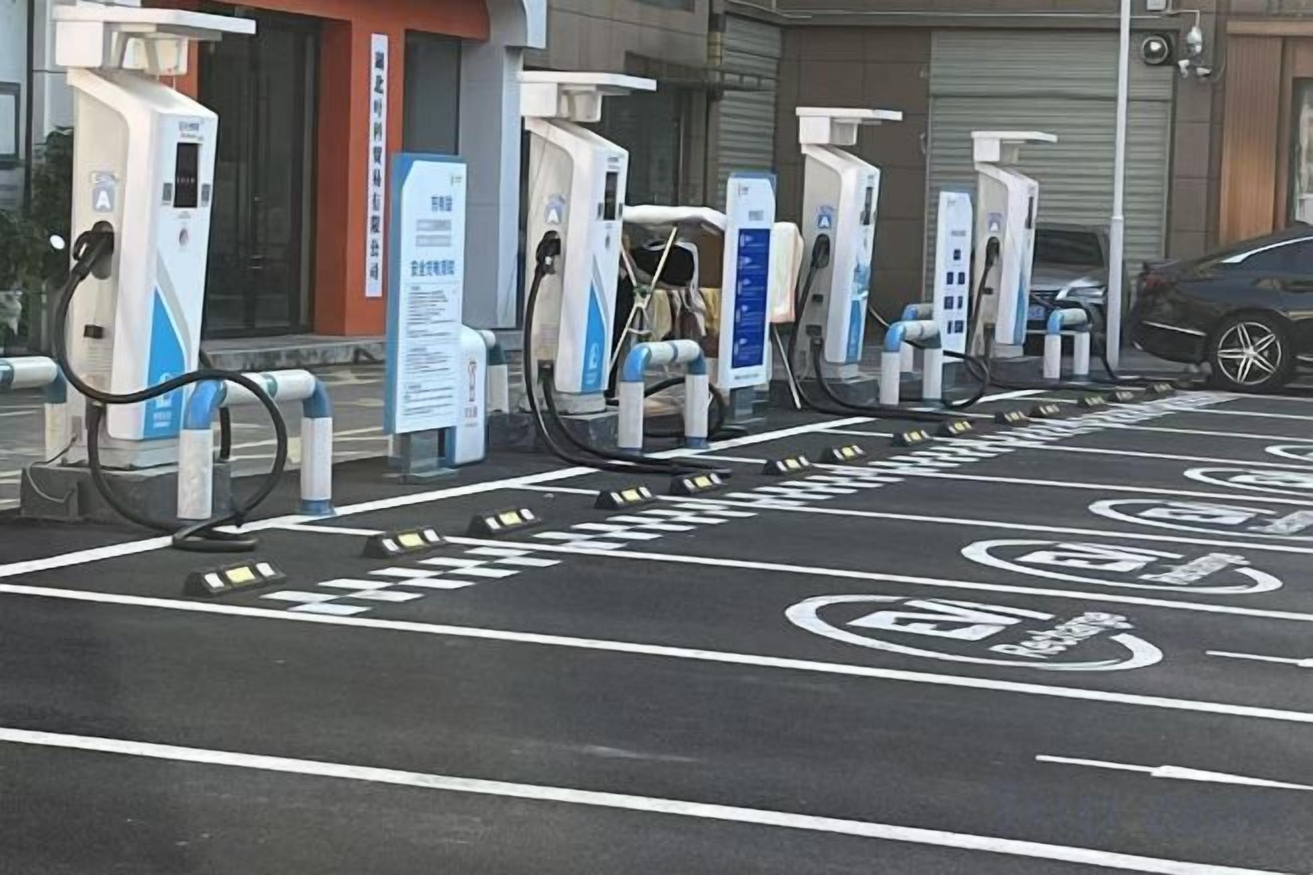 A row of electric vehicle charging stations with a parking area marked for EVs.