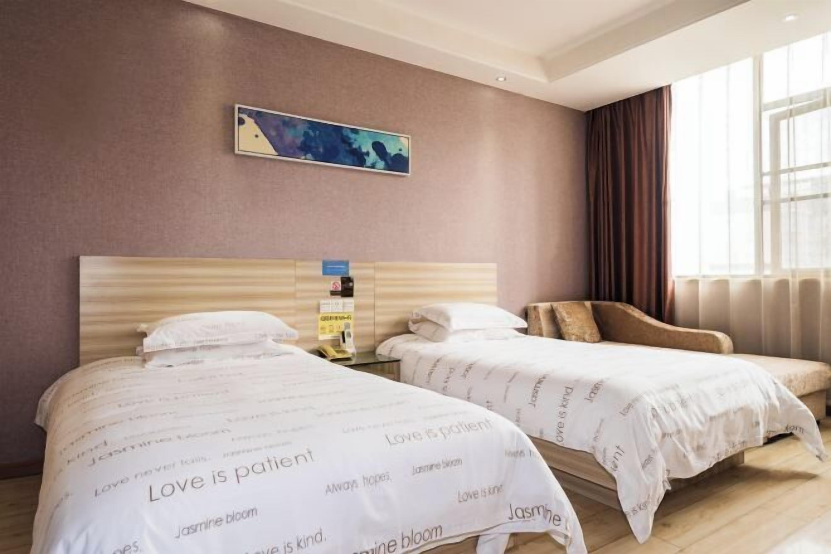 A hotel room with two beds, a nightstand, a painting on the wall, and a window with curtains.