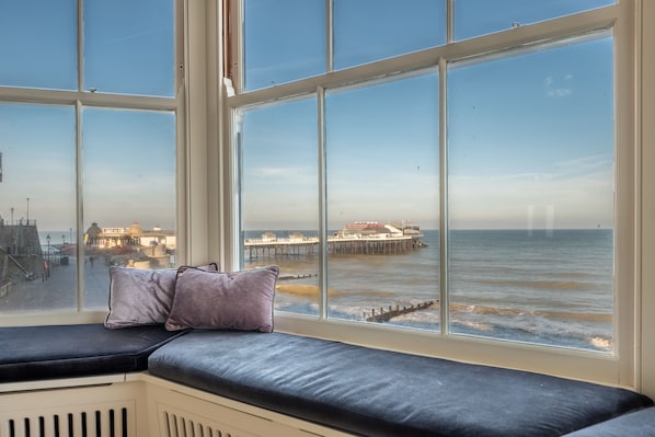 A room with a large window overlooking a pier and the sea. - Boycott House, Cromer, Norfolk (Cromer)