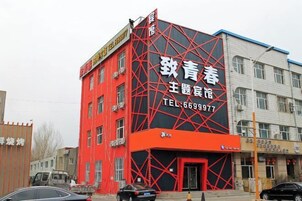 Un edificio con fachada roja y un cartel grande con caracteres chinos.