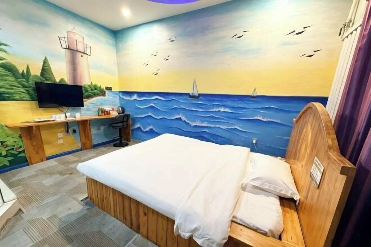 Une chambre à coucher avec un lit, un bureau et un téléviseur.