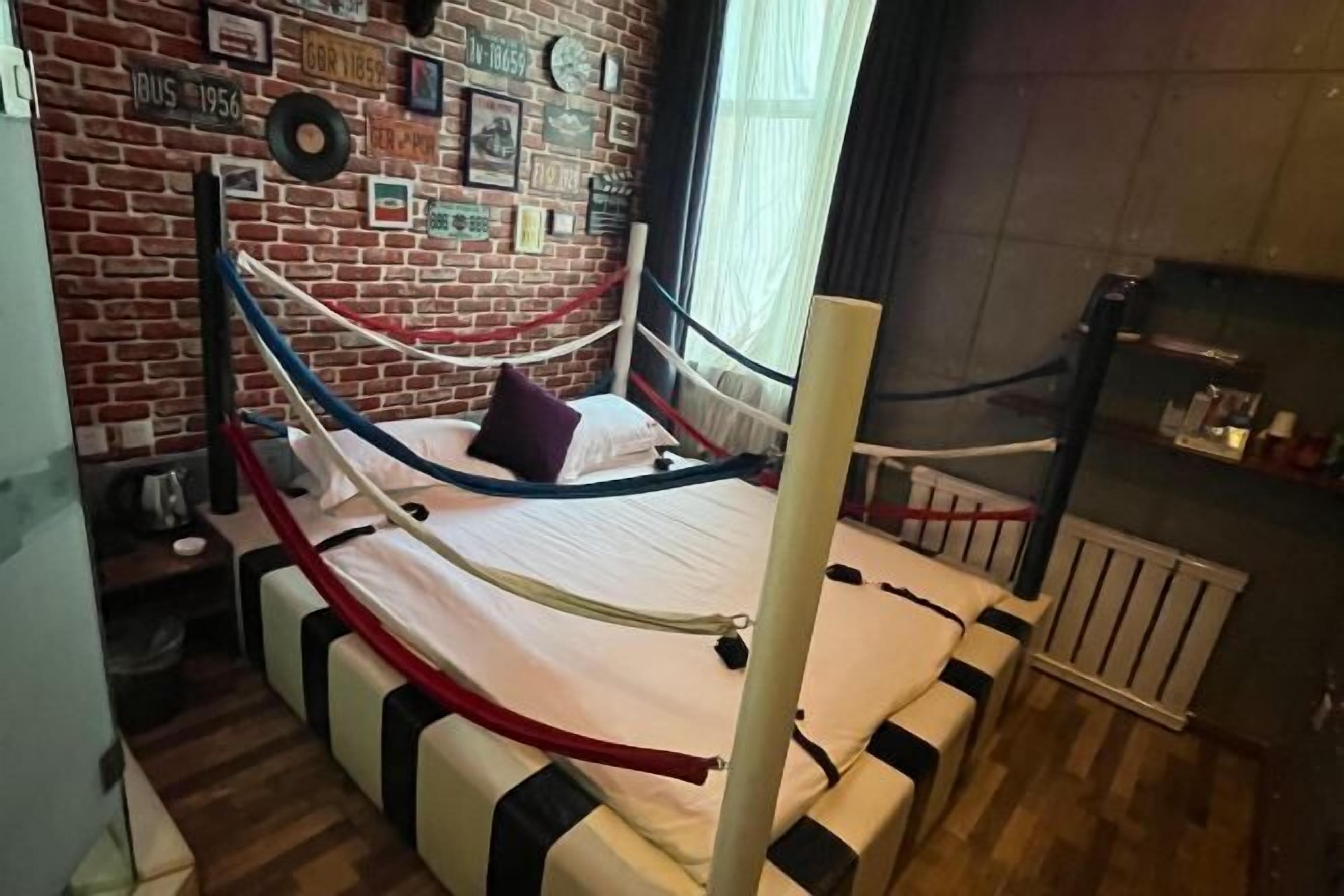 A room with a bed, a brick wall, and a window.