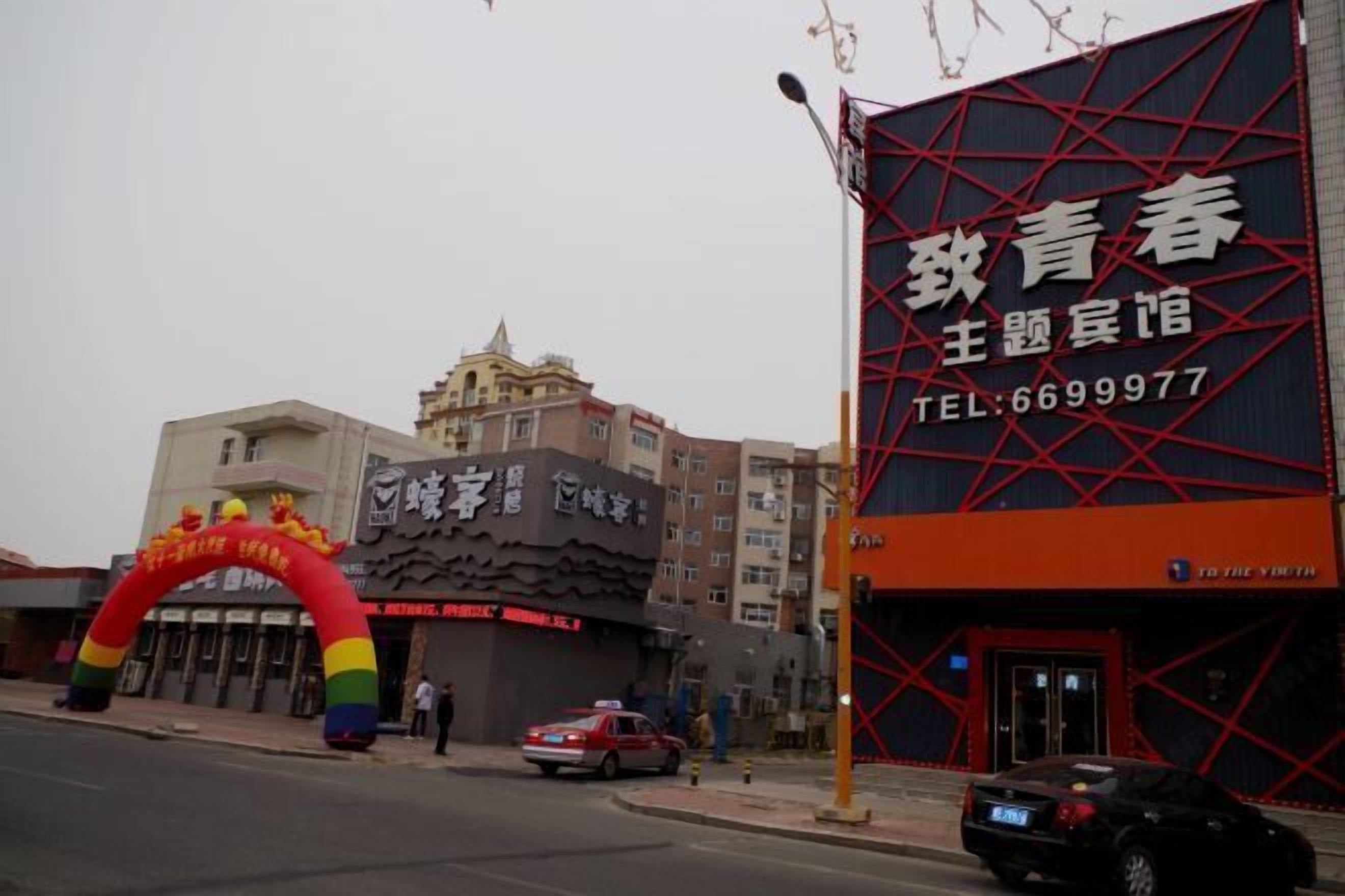 A building with a large signboard and a colorful archway.