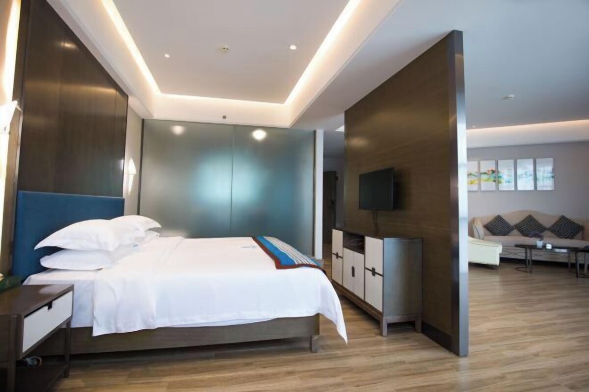Une chambre d’hôtel moderne équipée d’un lit, d’une télévision, d’un canapé et d’une table à manger.