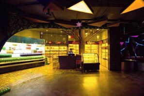 Une épicerie bien éclairée, dotée d’un rayon réfrigéré et d’une zone de caisses.