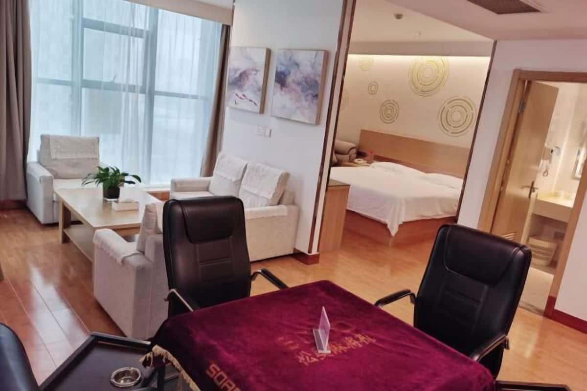 Una habitación de hotel con cama, escritorio, sofá y mesa de comedor.