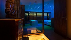 A room with a bed, a desk, and a statue. There is a view of the sky through a glass door. - Villa Eva w/ Pool & Spa in Goriška Brda, Dobrovo v Brdih, Slovenia (Dobrovo v Brdih)
