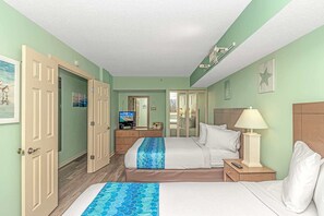 A hotel room with two beds, a television, a desk with a lamp, and a wardrobe.