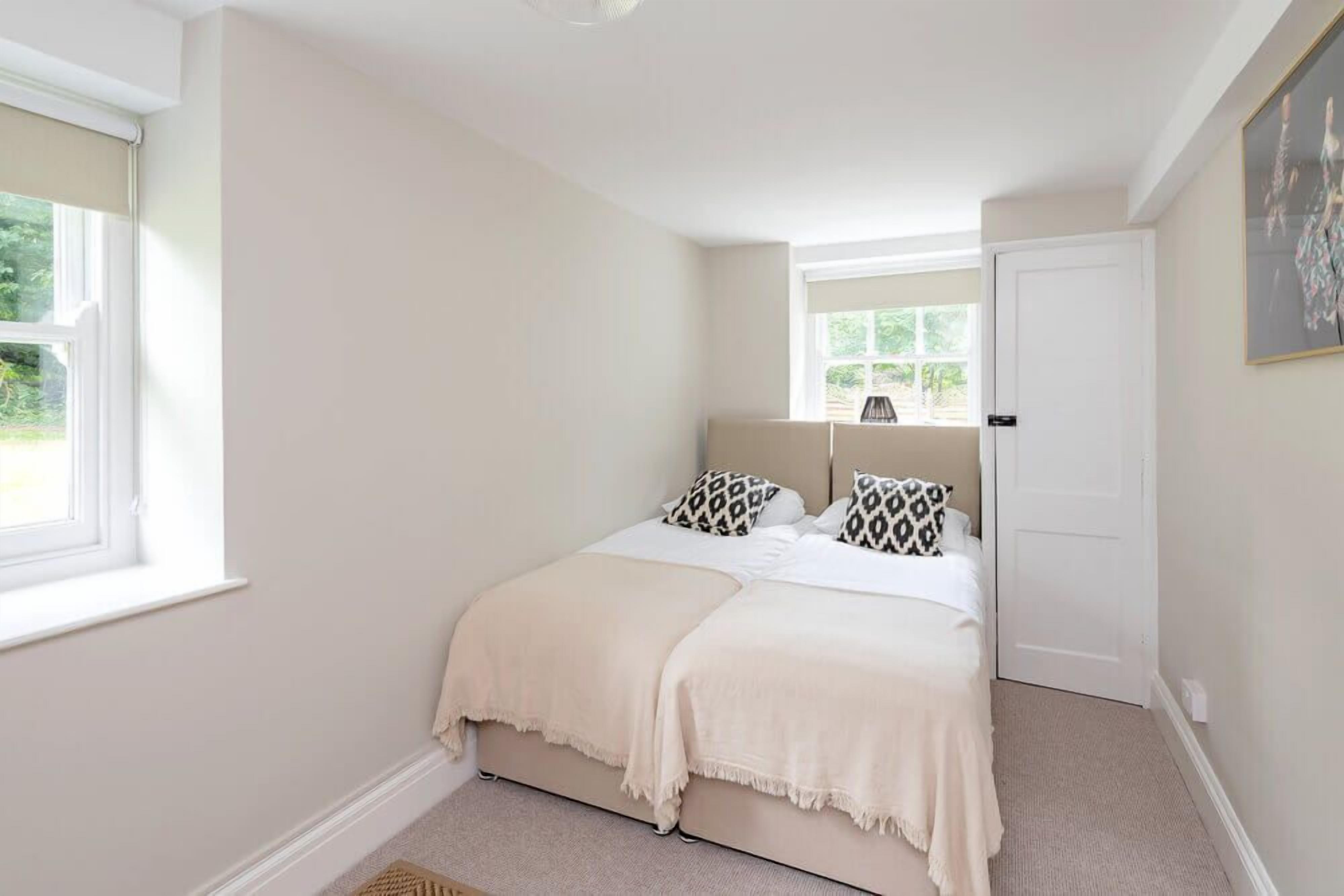 A bedroom with a bed, a window, and a door.
