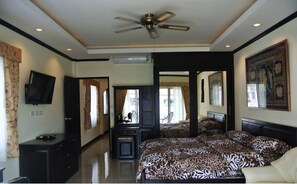 Relax in a spacious room with a large bed, ceiling fan, flat-screen TV, and large window.