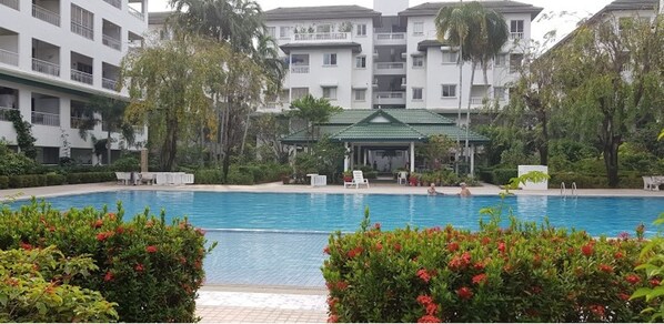 Guests can enjoy a refreshing swim in the pool surrounded by lush gardens and vibrant flowers.