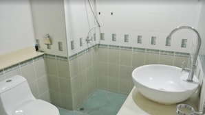 Ein kleines Badezimmer mit Toilette, Waschbecken und Dusche.