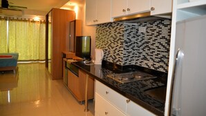 Uma cozinha moderna com armários brancos, bancada preta e painel de azulejos.