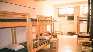 Un dormitorio con literas, una mesita y una silla.