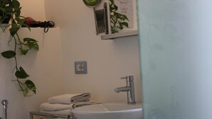 Une salle de bain avec un lavabo blanc, un miroir et un porte-serviettes.
