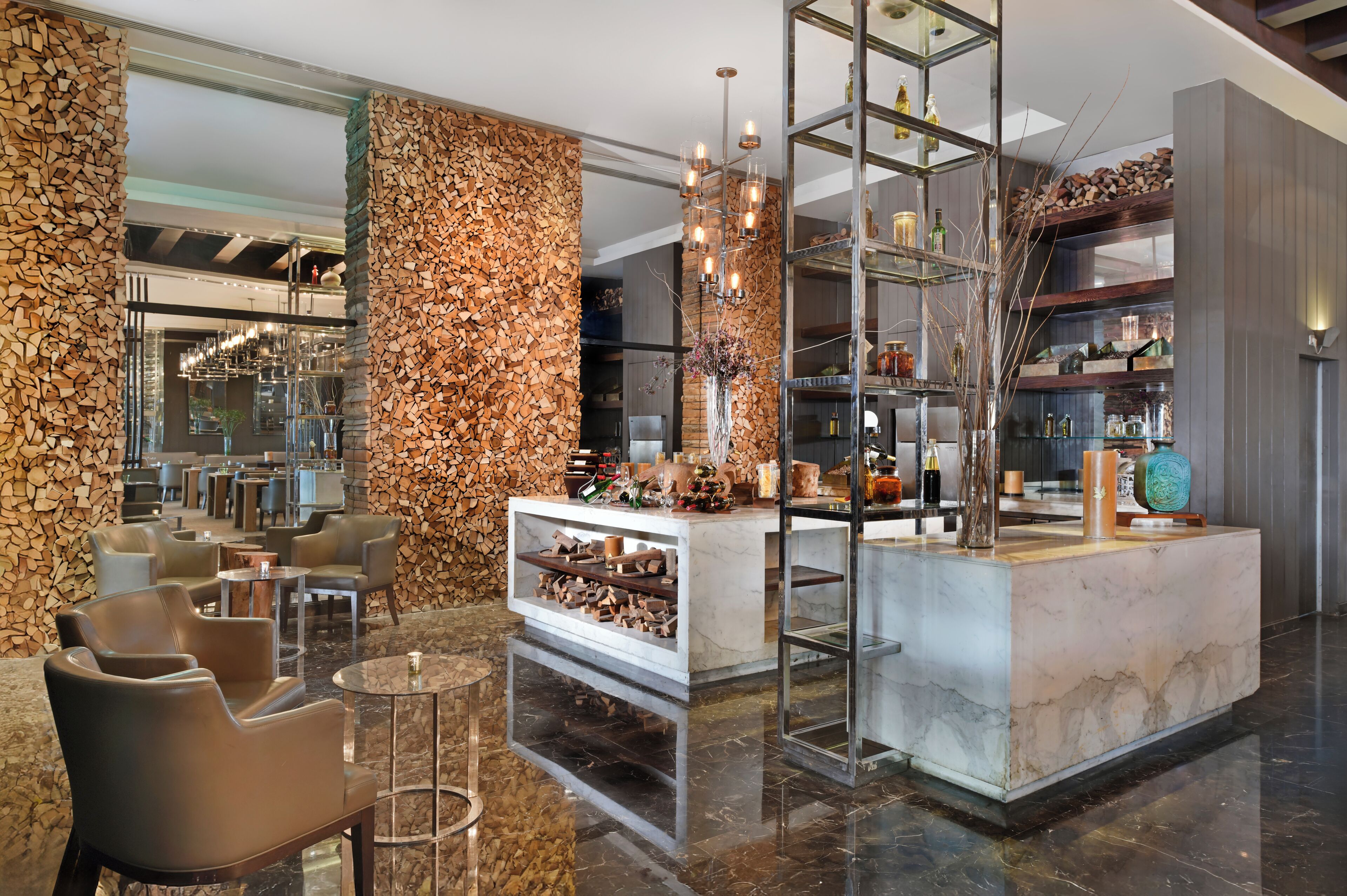 A modern lobby with a reception desk, seating area, and a decorative wall.