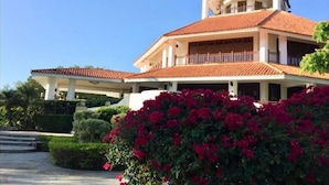 Un edificio a due piani con tetto in tegole rosse, una torre centrale e un portico coperto.