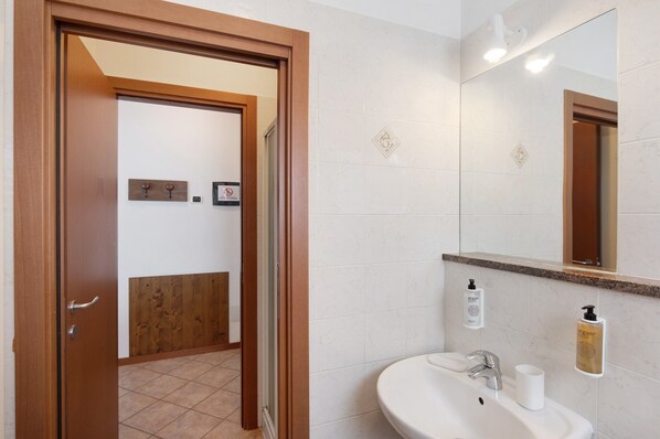 Een badkamer met een wastafel, spiegel en toiletartikelen.
