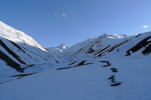 Un paysage de montagne enneigé, sous un ciel dégagé.