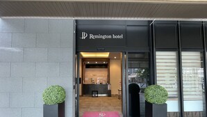 The entrance to Remington hotel with a reception desk, a check-in counter, and a digital display. - Remington Hotel (Akashi)