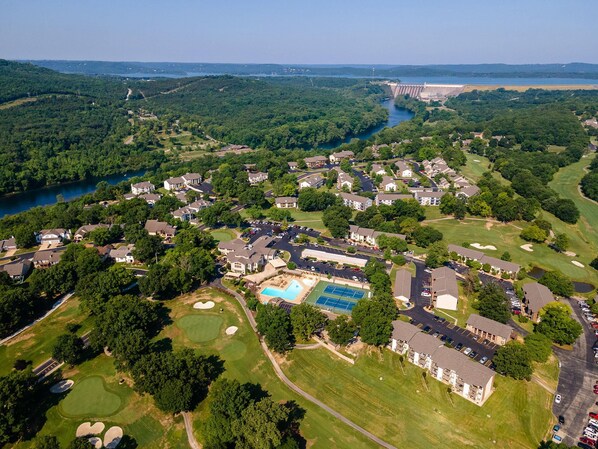 An aerial view of a residential area with houses, a swimming pool, and a golf course.