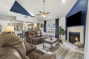 A modern living room with a leather sofa, a wooden coffee table, and a fireplace.