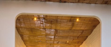 A spa area with a hot tub, wooden steps, and wall-mounted lights.