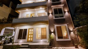 A multi-story building with balconies, large windows, and a well-lit entrance. - Stay inn nest (Bhopal)