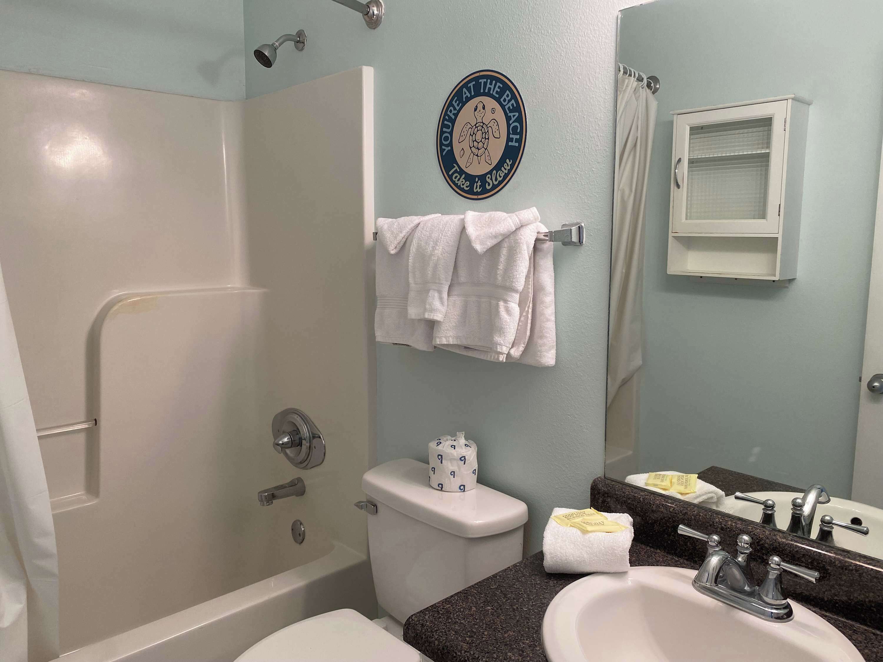 Une salle de bain équipée d’une baignoire, de toilettes, d’un lavabo et d’un porte-serviettes avec des serviettes.