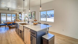 Una cocina amplia con una isla grande, electrodomésticos modernos y ventanas que ofrecen vistas a un paisaje nevado.