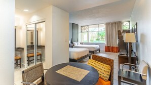 Una habitación de hotel con una cama, un escritorio, una silla, una mesa y una ventana con cortinas.