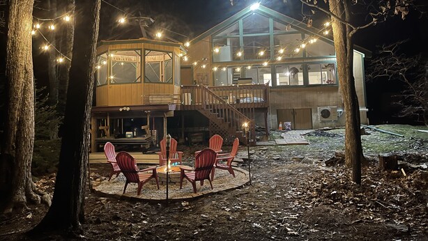 A two-story wooden cabin with a deck and outdoor seating area. - Relaxing Rustic ranch at Locust Lake!  with beautiful views!  Close to the Lake! (Pocono Lake)