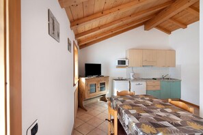 Una cocina compacta con armarios de madera, un microondas y un refrigerador pequeño.