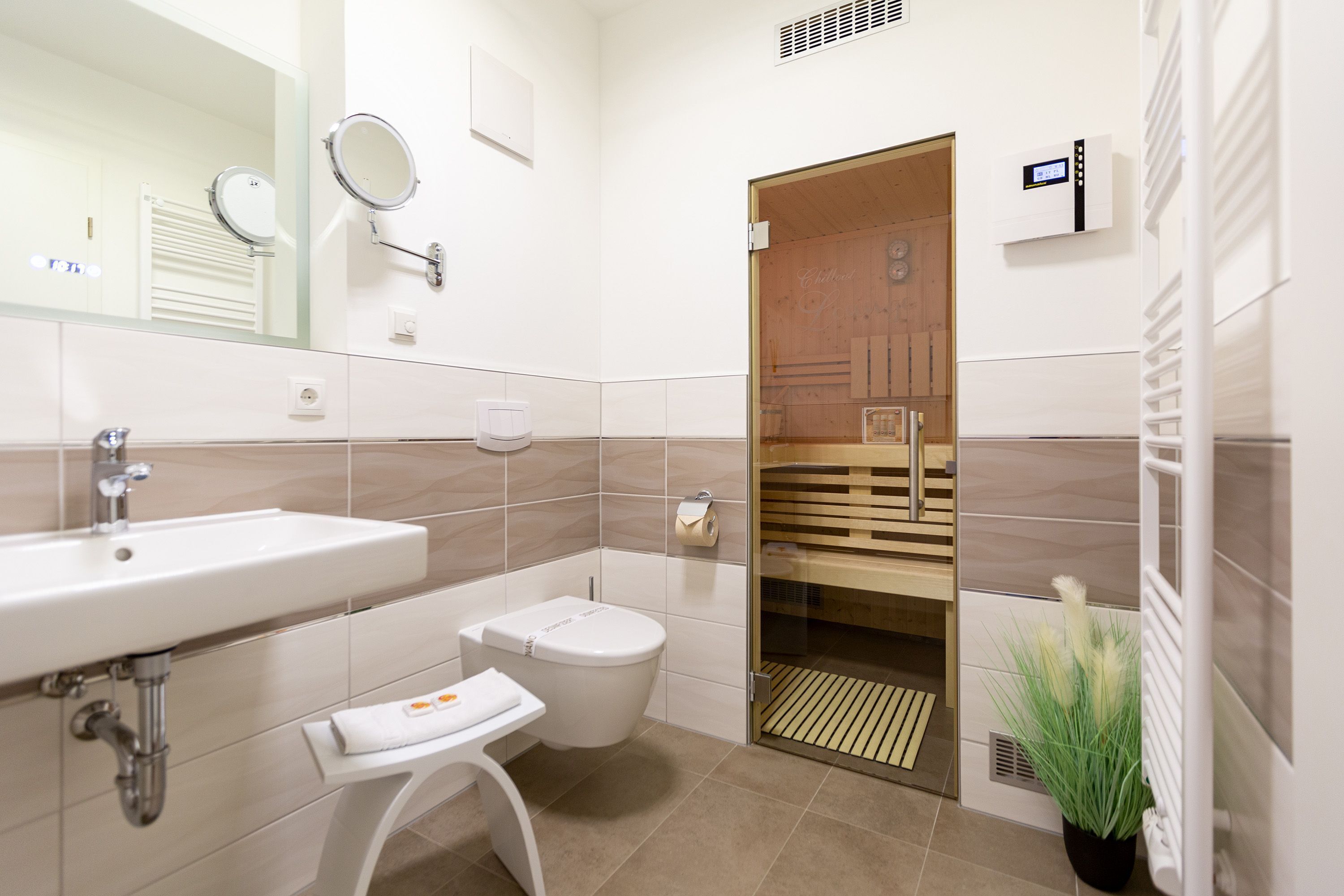 A modern bathroom with a sink, toilet, and a glass shower enclosure.