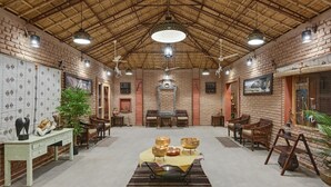 A spacious room with a high ceiling, brick walls, and a central table with decorative bowls.