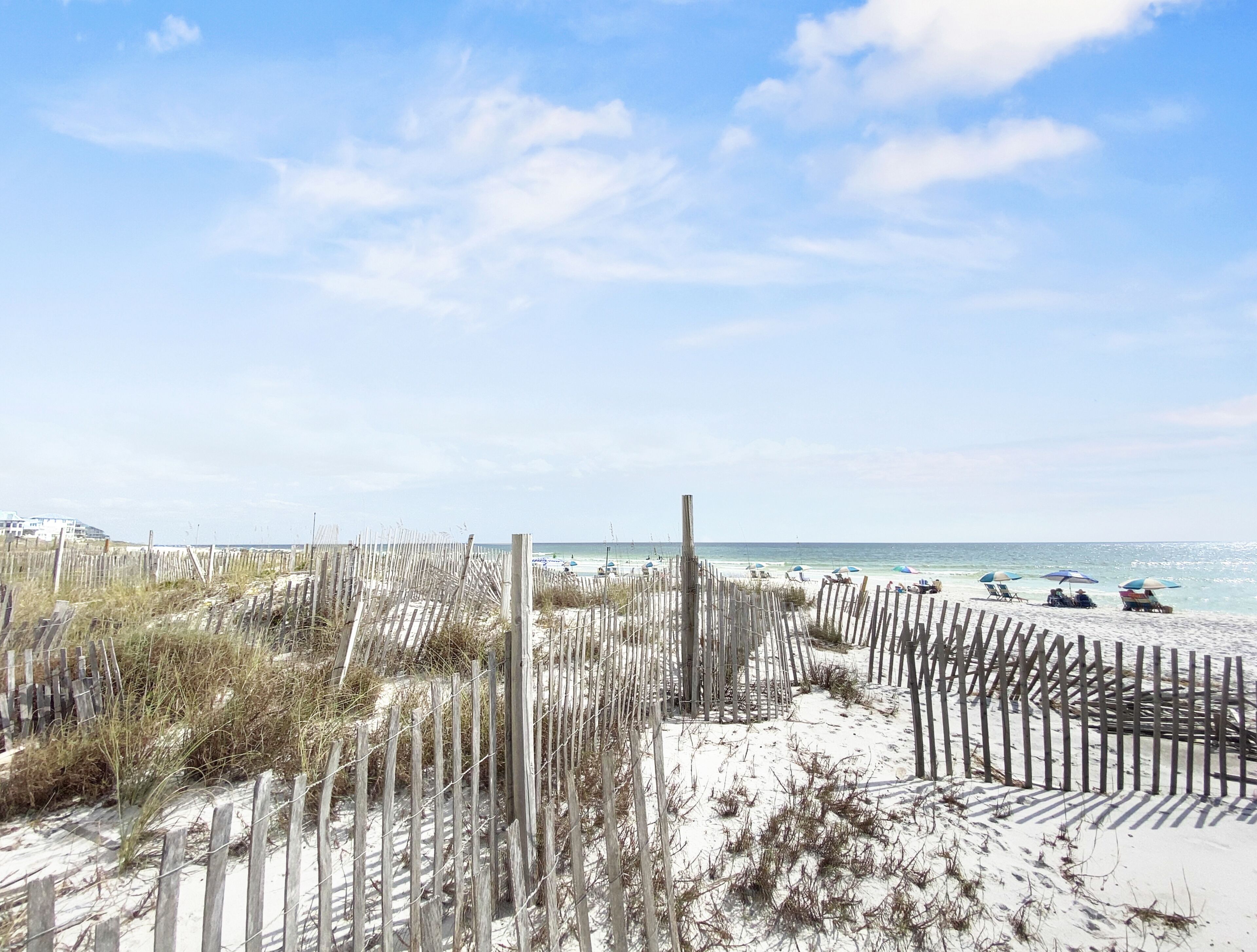 A beach with wooden fences and beach chairs.