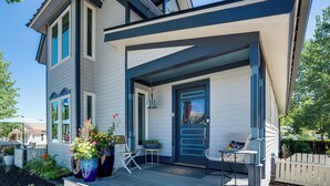 A modern house with a covered porch, a front door, and a small table and chair set. - Hot Tub! Dtwn Breckenridge 'Alpenglow' Home (Breckenridge)