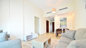 Una sala de estar moderna con sofá, mesa de centro y mueble para televisión.