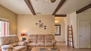 A living room with a beige sofa, a wooden coffee table, and a red lamp. - Borrego Springs Stargazing Home w/ Mtn Views (Borrego Springs)