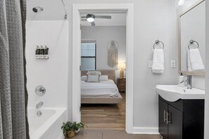 A modern bathroom with a bathtub, a sink, and a mirror.