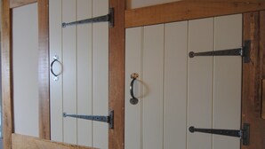 A wooden staircase with a handrail and a door with a metal handle. - Courtyard Cottages Lymington (Lymington)