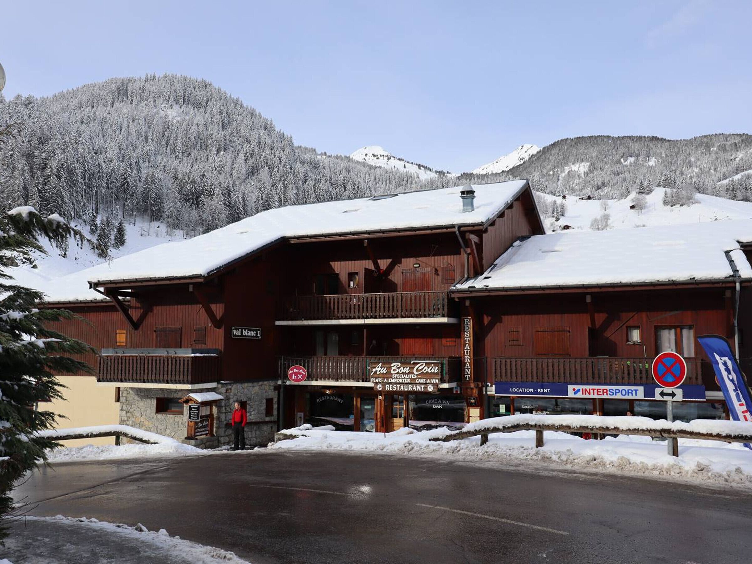 Een houten gebouw met een restaurantsbord, een skilift en een berg op de achtergrond.