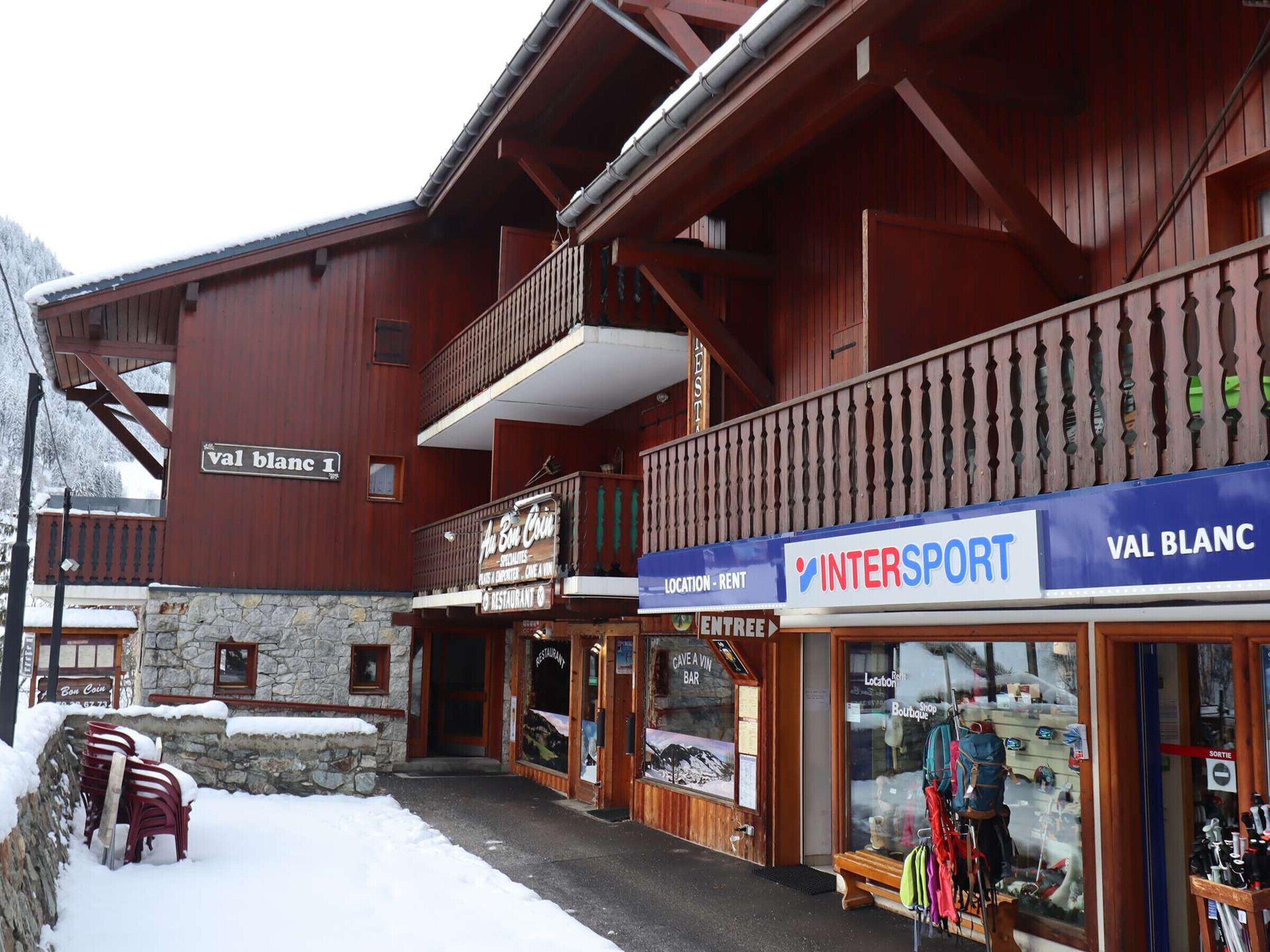 A building with a sign reading "val blanc I" and a storefront with "INTERSPORT" and "VAL BLANC" signs.
