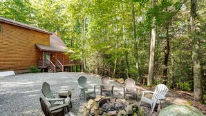 Une cabane avec un foyer et des sièges d’extérieur.