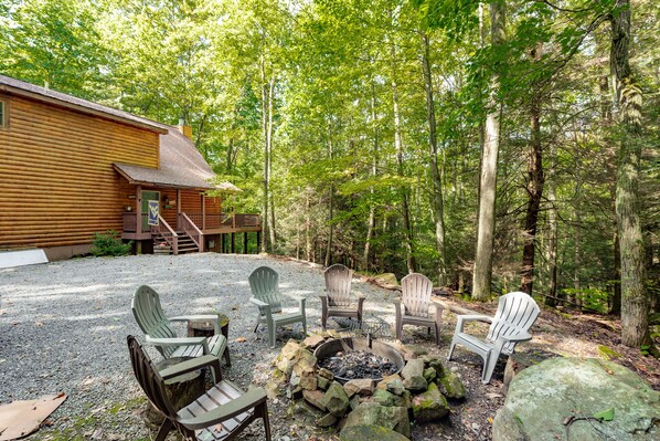 A cabin with a fire pit and outdoor seating.